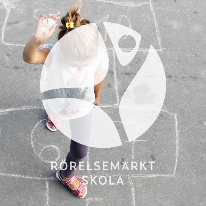 Rörelsemärkt skola logotyp vit på bild av flicka på skolgård